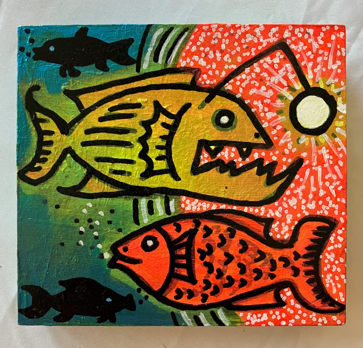 Fearless: a yellow fish and an orange fish facing each other across a red and teal field, a white sun between them.
